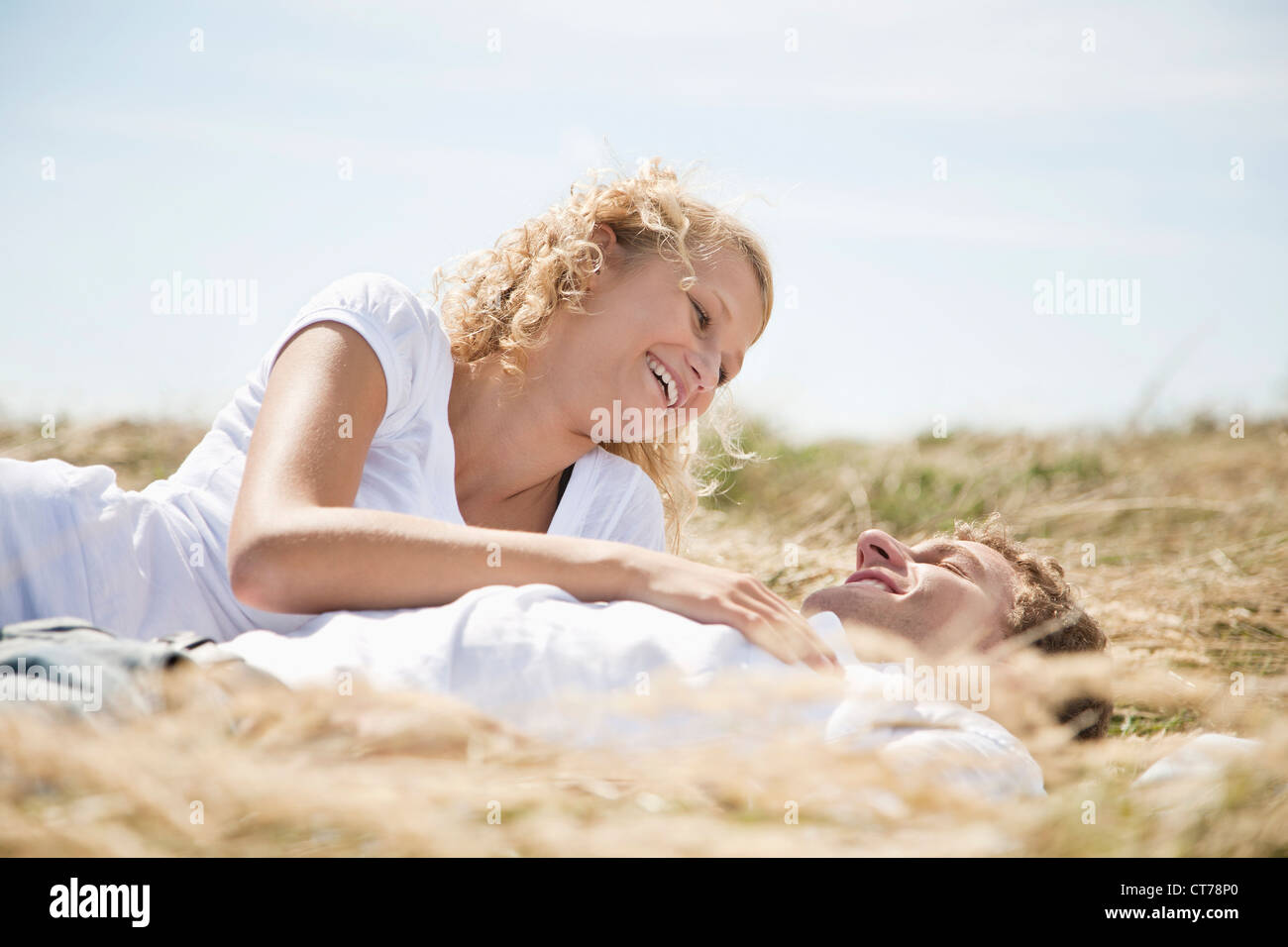 Jeune couple lying in field en été Banque D'Images