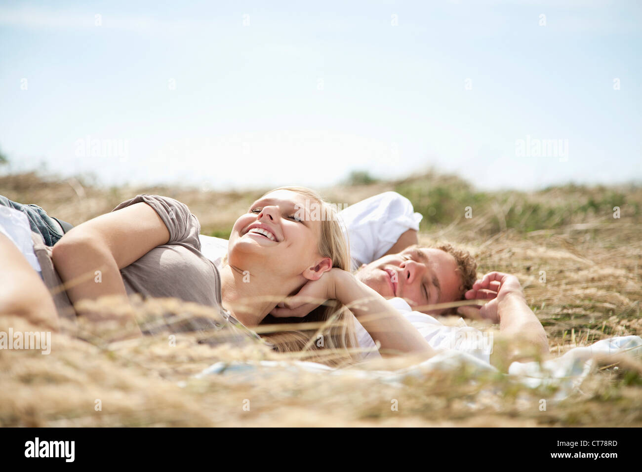 Jeune couple lying in field en été Banque D'Images