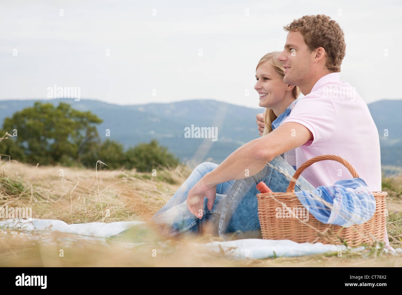 Young couple having picnic in field Banque D'Images
