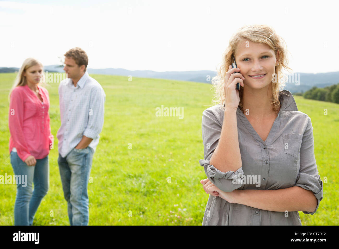 Young Woman talking on mobile phone on meadow Banque D'Images