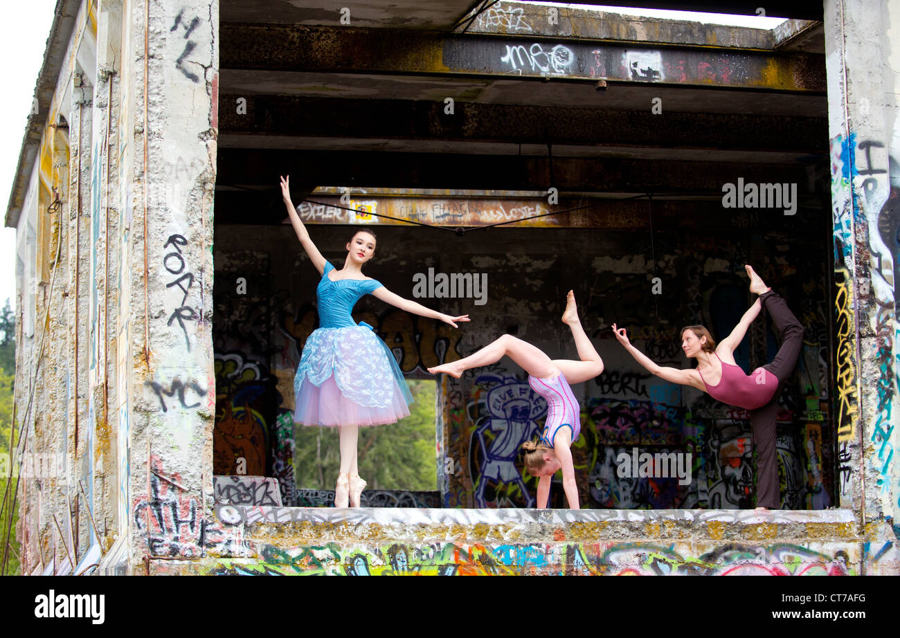 Gymnaste et ballerines en spectacle avec graffiti sur mur Banque D'Images