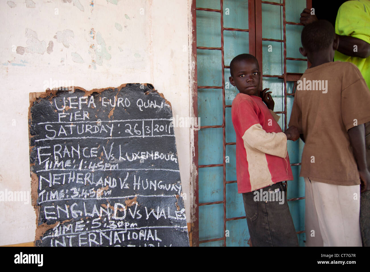Pancarte mettant en valeur les jeux de football qui sont joués sur le village local de la télévision sur la soirée à venir à Migori, Kenya. Banque D'Images
