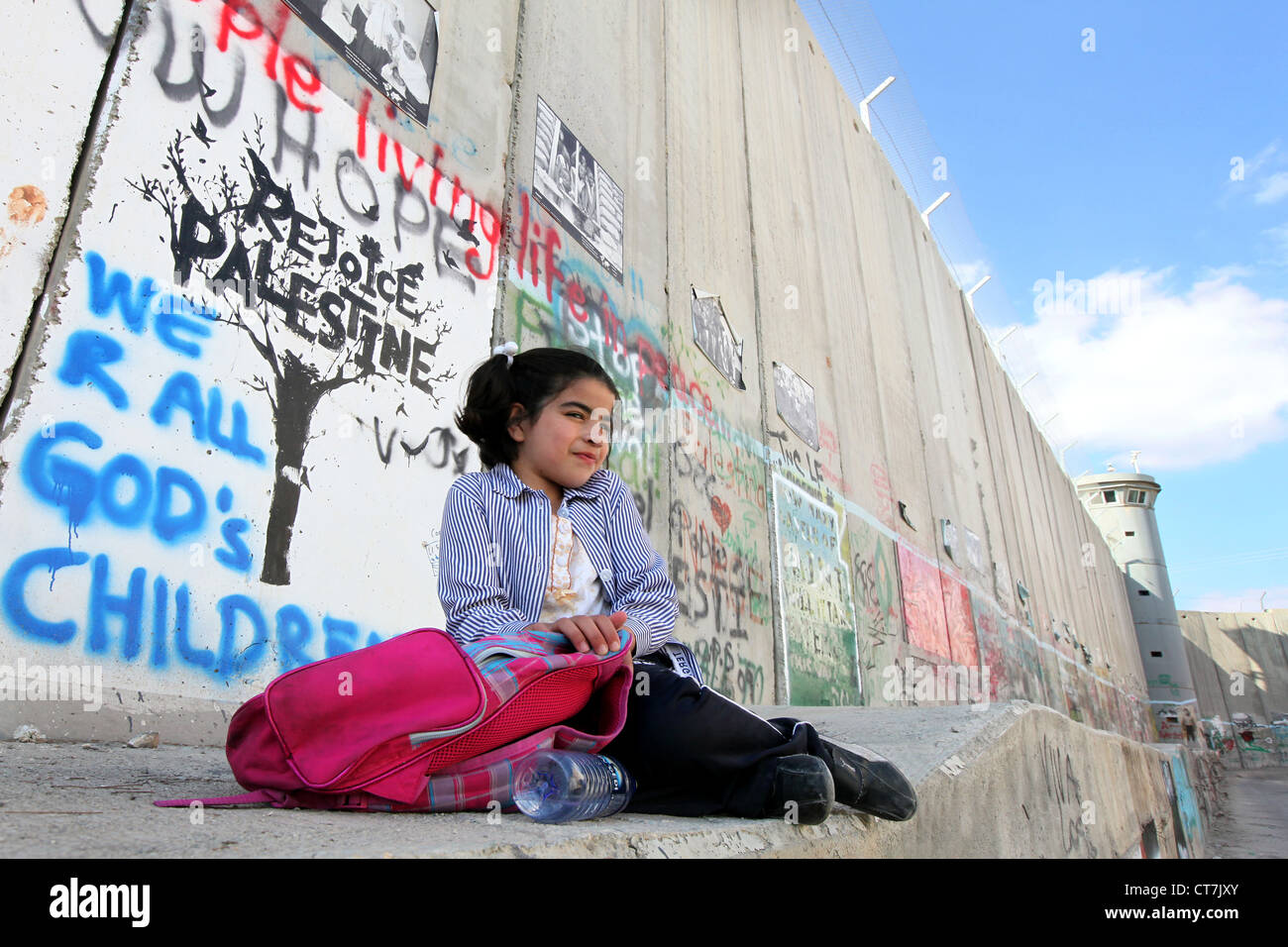 Fille assise sur le mur de séparation israélien. Ce mur sépare les terres palestiniennes en Cisjordanie près du Checkpoint de Bethléem Banque D'Images