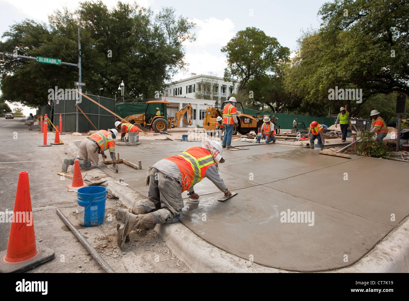 Industrial travailleurs béton Béton complète trottoir en face de l'hôtel récemment rénové maison du gouverneur du Texas à Austin, Texas Banque D'Images