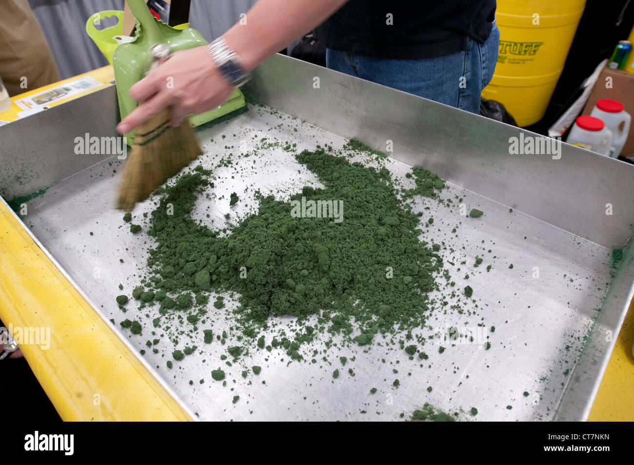 Absorbant les matières dangereuses 'Green Stuff' est utilisé sur l'huile de l'échantillon et de l'antigel à un salon commercial de qualité de l'environnement. Banque D'Images