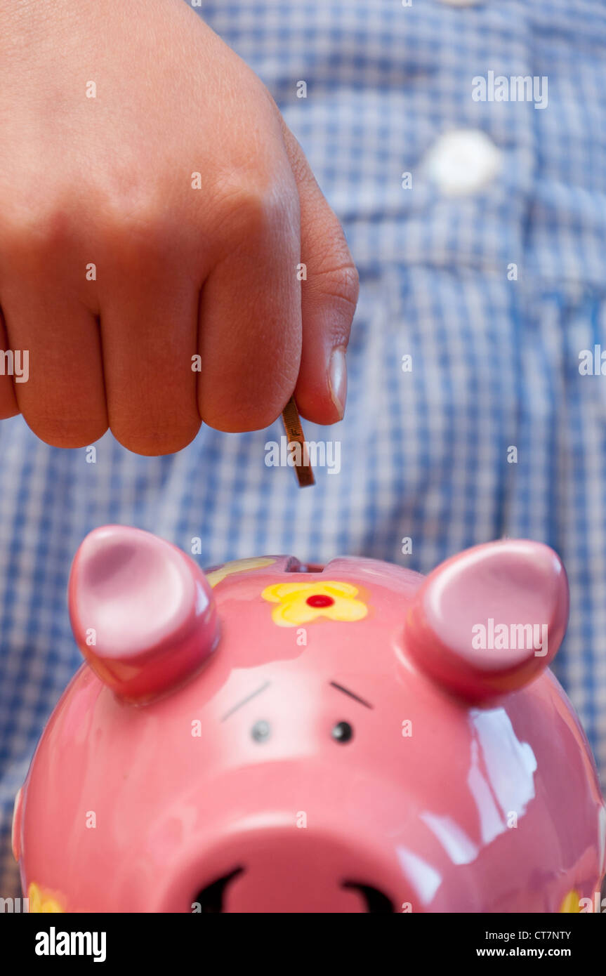 Enfant d'économiser de l'argent dans la tirelire. Banque D'Images