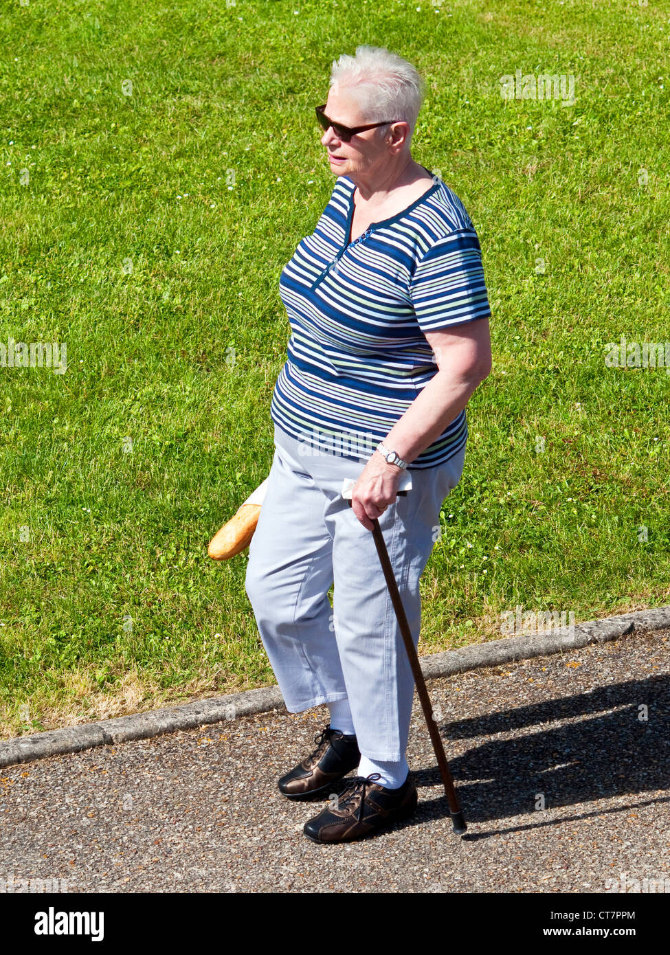 Femme âgée marcher avec stick - France. Banque D'Images