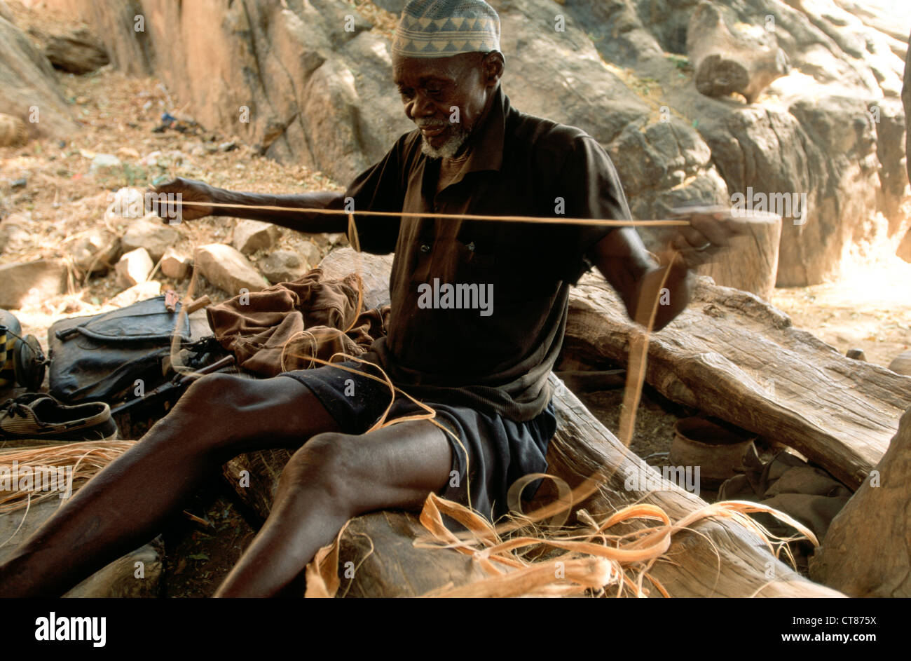 Pays dogon, Mali ; l'homme la fabrication de cordes à partir de l'écorce du baobab Banque D'Images