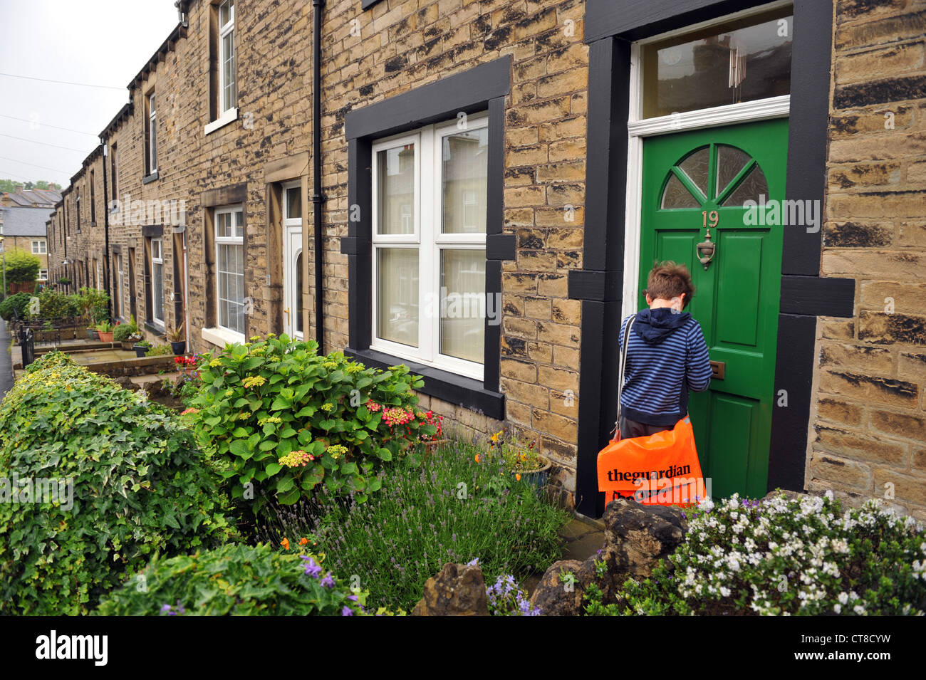 Un garçon papier fournit des documents sur les rues, Yorkshire UK MODEL PUBLIÉ Banque D'Images