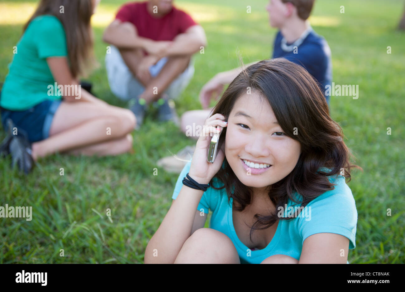 Jeune fille asiatique à parler au téléphone à l'extérieur Banque D'Images