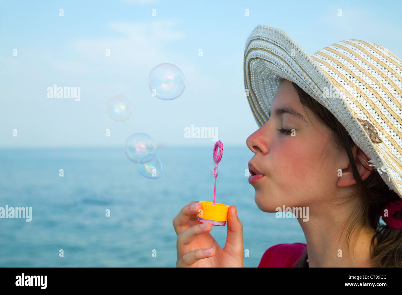 Teen girl blowing Bubbles at sea shore Banque D'Images