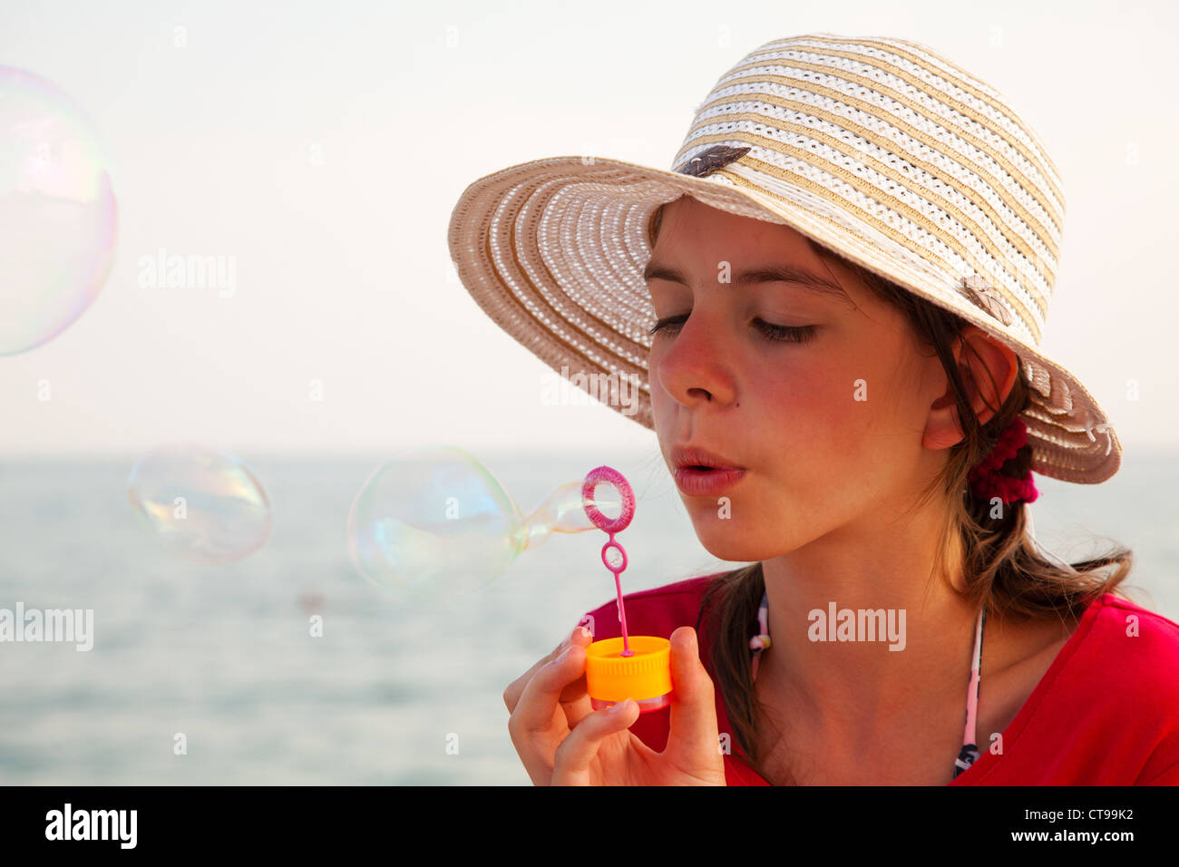 Teen girl blowing Bubbles at sea shore Banque D'Images