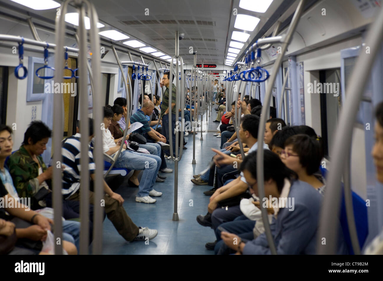 À l'intérieur du tube de métro train avec compartiment voyageurs chinois de banlieue / passagers. Système souterrain. Beijing, Chine Banque D'Images