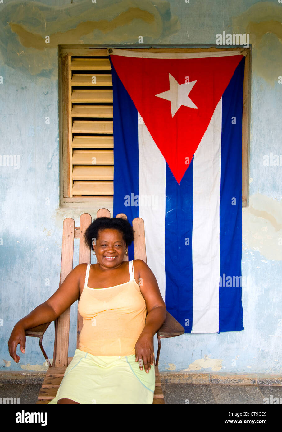 Femme sur le porche avec drapeau cubain, Viñales, Cuba Banque D'Images
