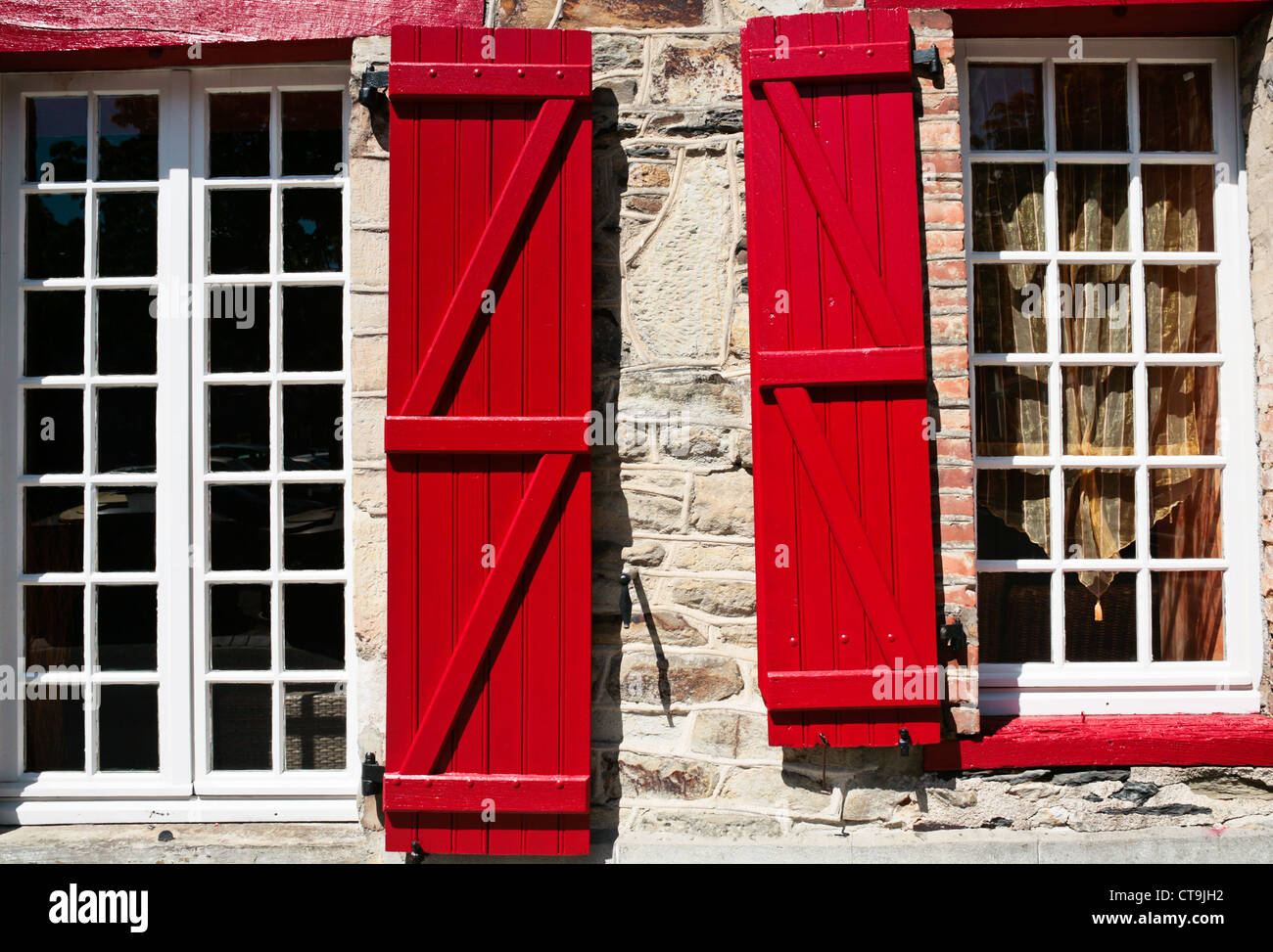 Fenêtres avec volets en bois rouge dans la vieille maison bretonne Banque D'Images
