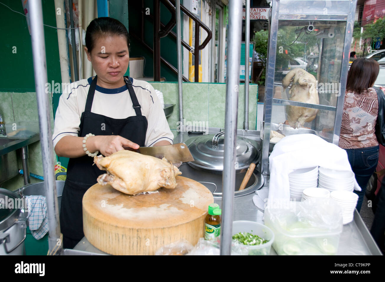 Un porte-food de couper un poulet rôti dans une des rues latérales à Bangkok, Thaïlande Banque D'Images