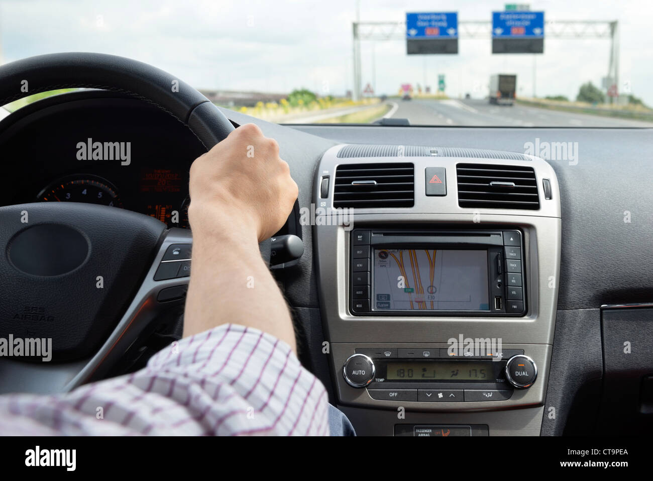 Main sur le volant d'une voiture de luxe, moderne, en prenant une sortie sur une autoroute Banque D'Images