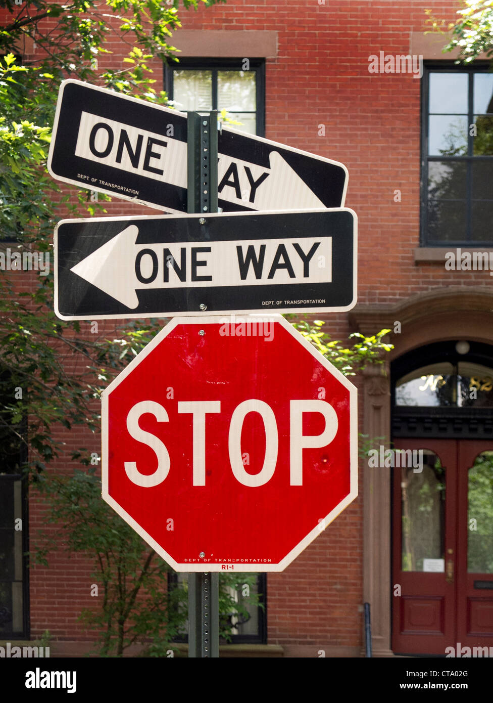 Les plaques de rue à sens unique pointant dans des directions opposées se contredisent à une intersection sur Brooklyn Heights, New York City Banque D'Images