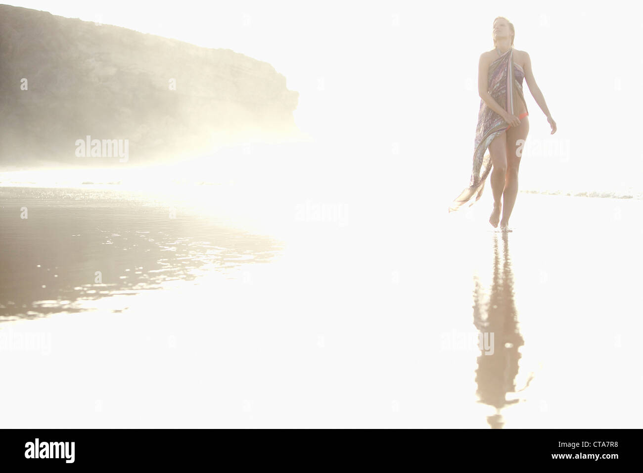 Jeune femme marche en eau peu profonde à plage, Fuerteventura, Espagne Banque D'Images