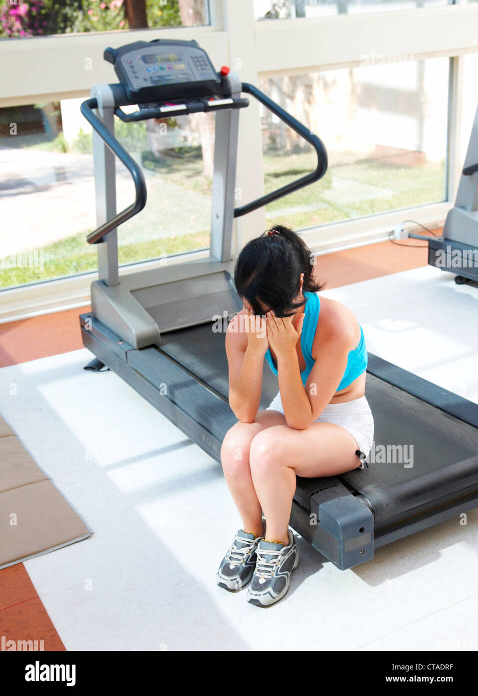 Cris de fille à un appareil d'entraînement sportif... Banque D'Images