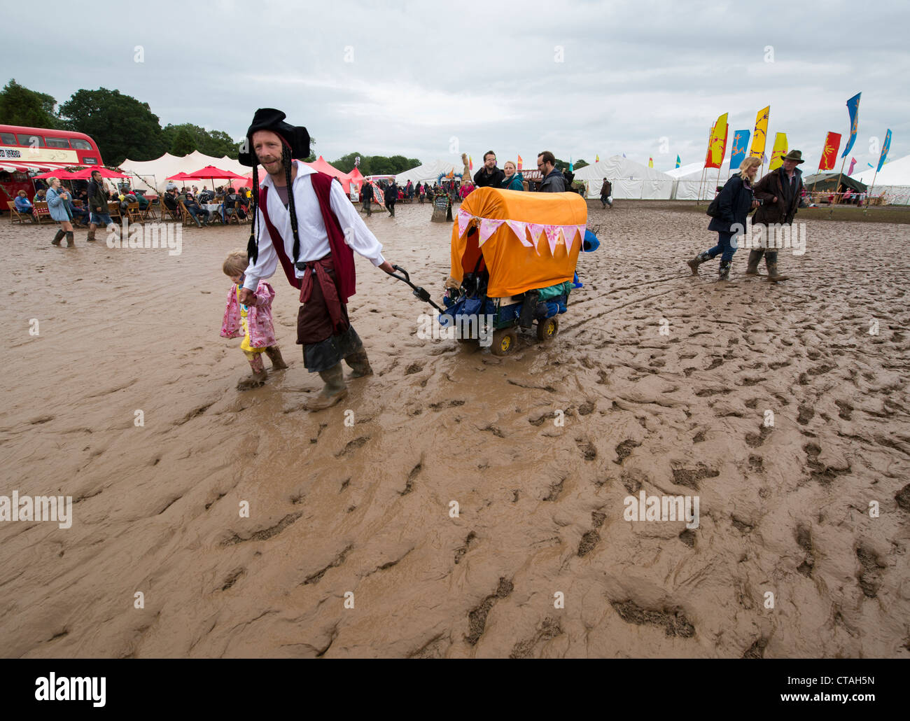 Les visiteurs de l'arbre dans le Dorset Festival Larmer braver les conditions boueuses après le mauvais temps d'un bout à l'UK Banque D'Images