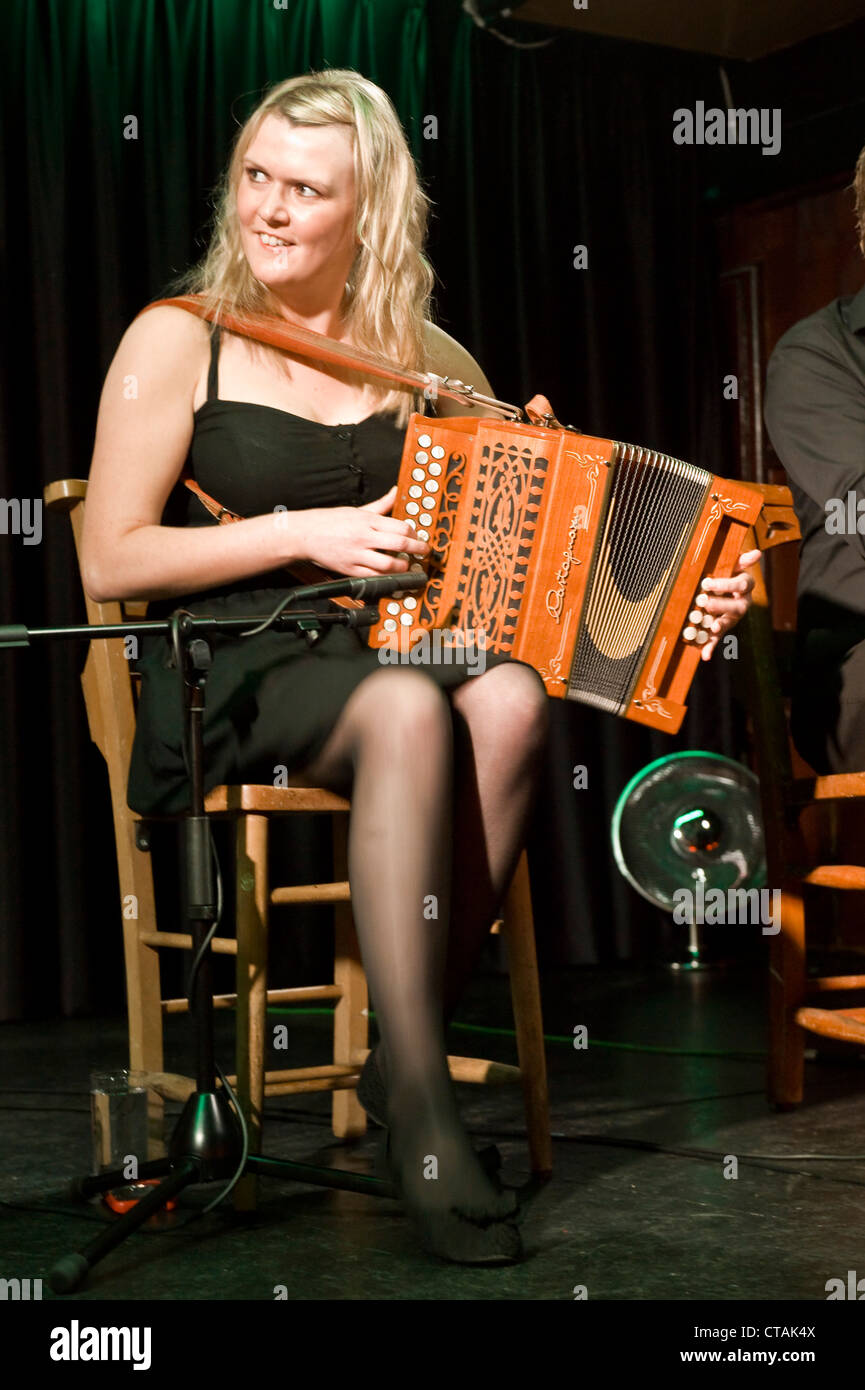 Lorraine jouer l'accordéon avec 'Púca" un groupe de musique traditionnelle irlandaise band à l'affiche à l'Arlington Hotel, Dublin. Banque D'Images