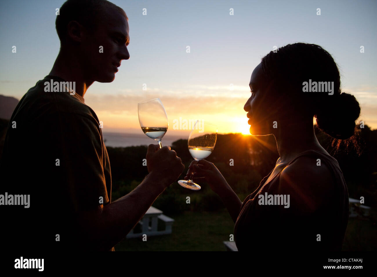 Homme Femme und bénéficiant d''un verre de vin blanc au soleil, Stellenbosch, Western Cape, Afrique du Sud Banque D'Images