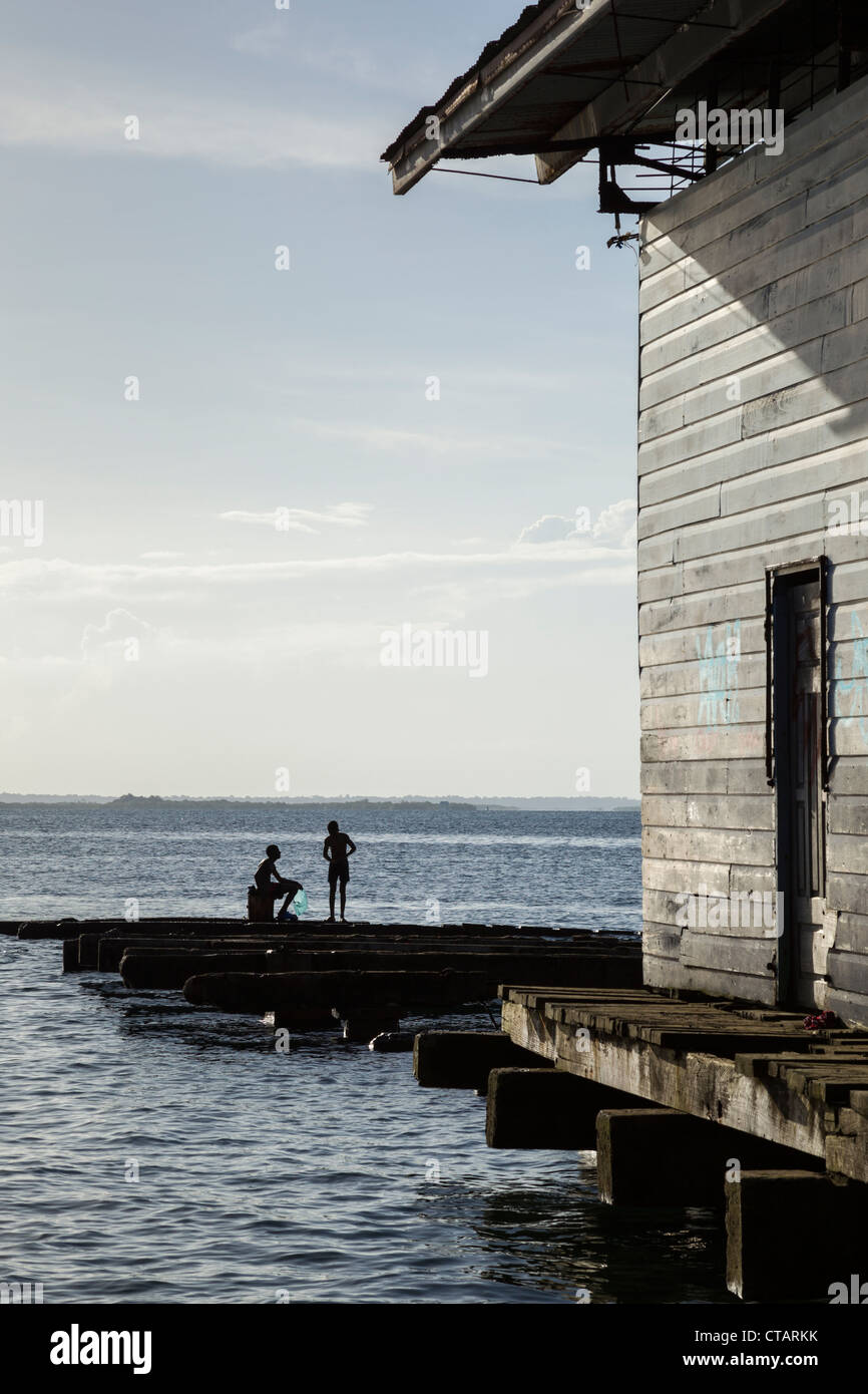 Deux garçons parler sur un quai rustique de l'Île de Colon, Bocas del Toro, PANAMA. Banque D'Images