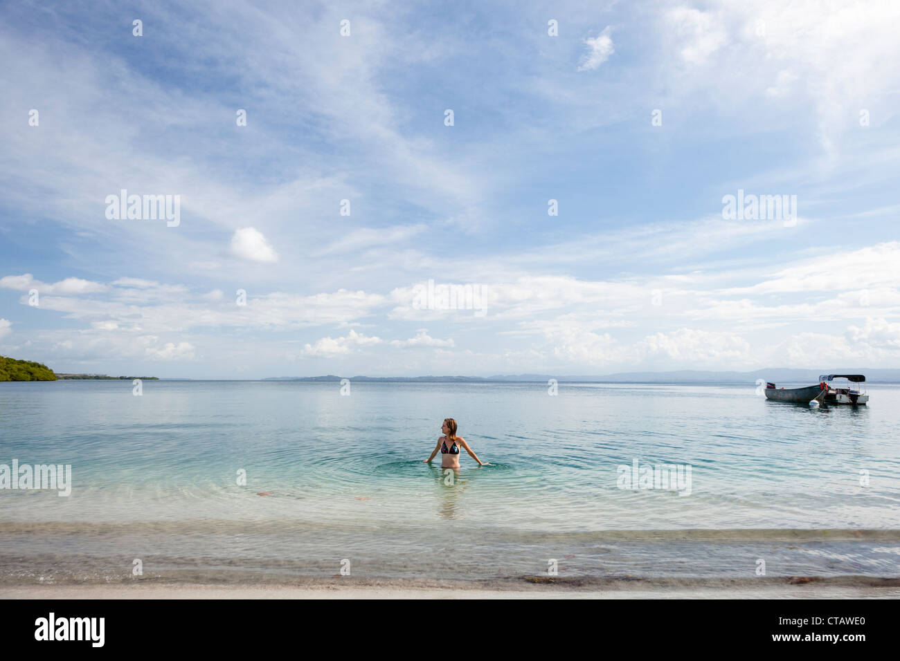 Femme de patauger dans la mer à Ocean Dunes sur l'Île de Colon, Bocas del Toro, PANAMA. Banque D'Images