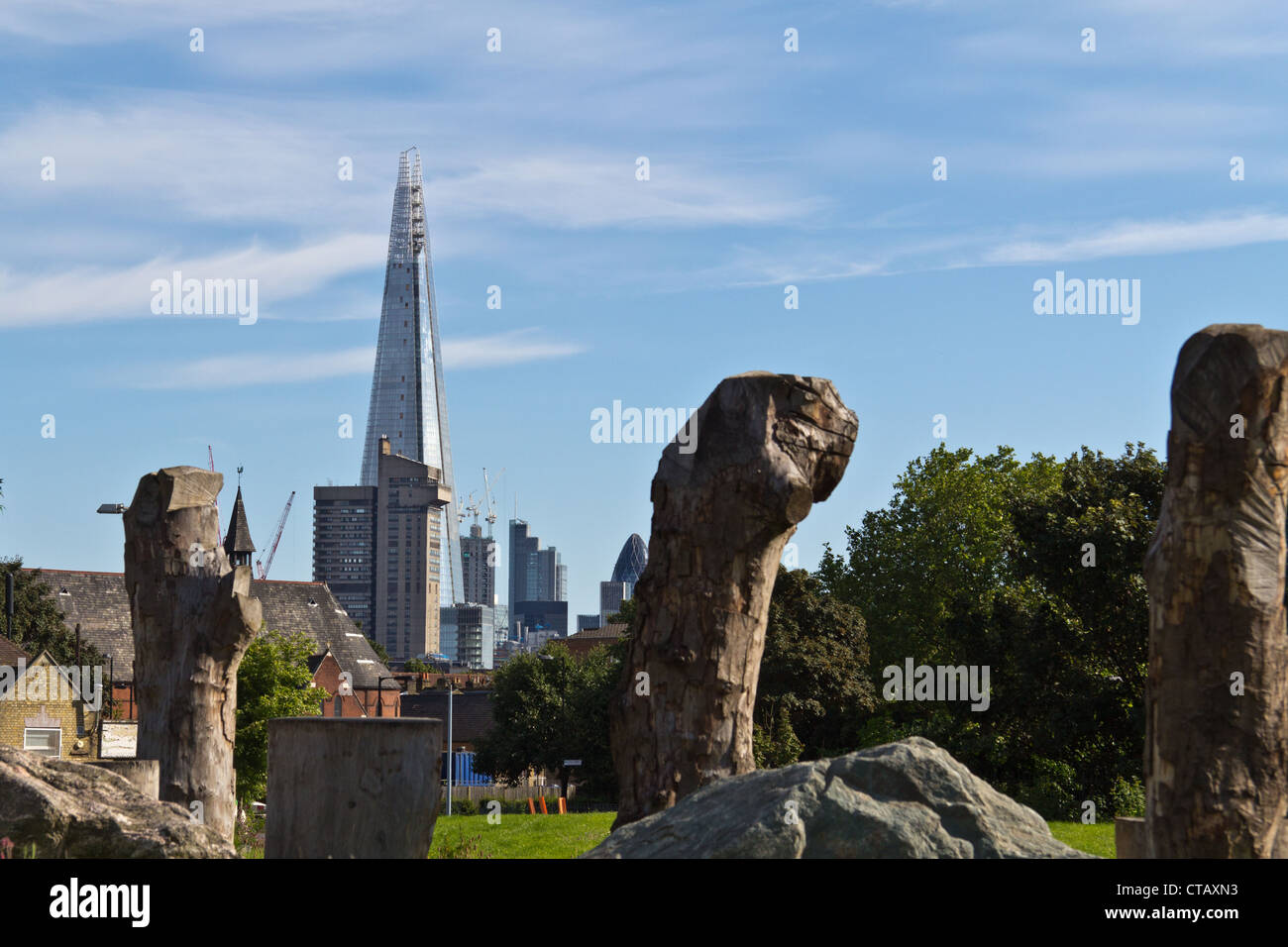 Sculptures en bois dans le parc par l'Est de la rue du marché dans le sud de Londres, et de l'Écharde de gars en arrière-plan de l'hôpital Banque D'Images