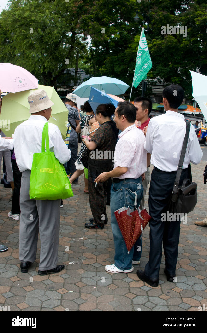 Guide de voyage officiel en tenant son drapeau pour conduire son groupe touristique pour découvrir les attractions locales à Bangkok, Thaïlande Banque D'Images