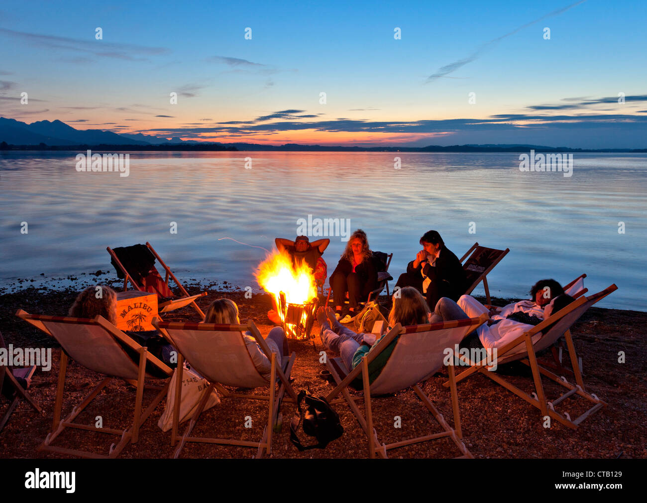 Groupe autour d'un feu de camp, lido Uebersee, le lac de Chiemsee, Chiemgau, Haute-Bavière, Allemagne Banque D'Images