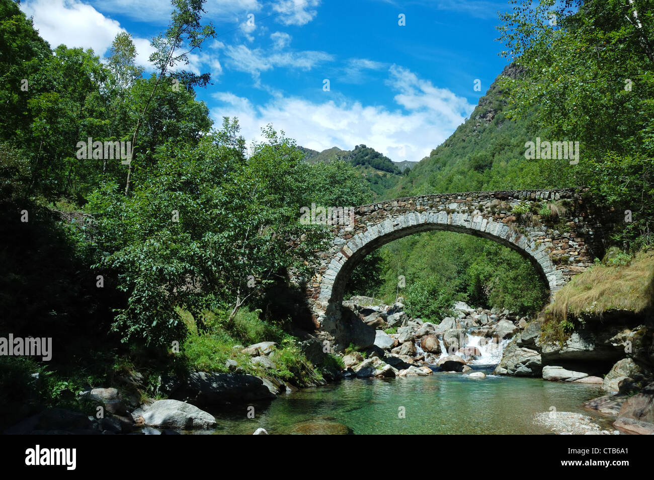 Pont en arc âgés de plus d'une petite rivière de montagne Banque D'Images