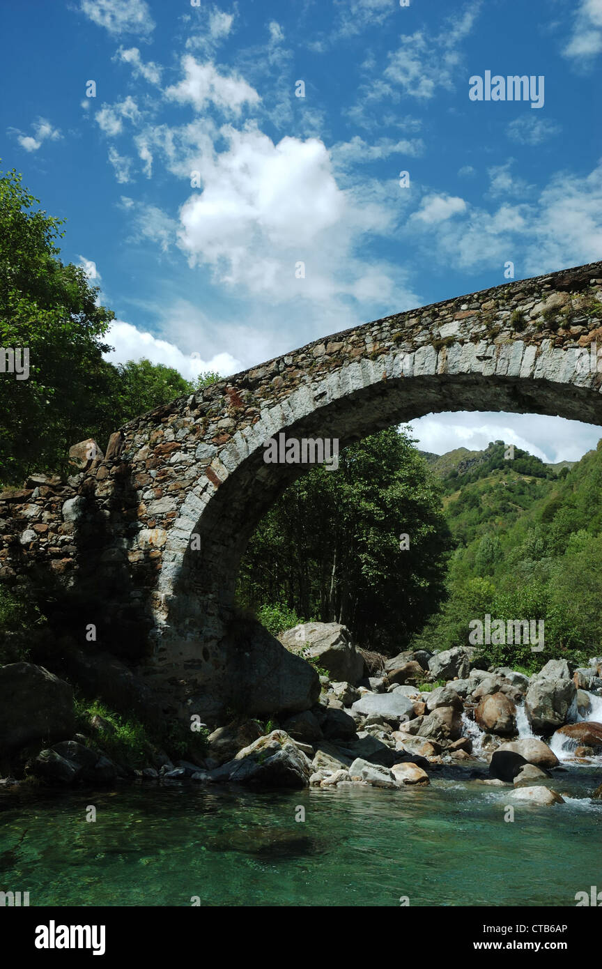 Pont en arc âgés de plus d'une petite rivière de montagne Banque D'Images