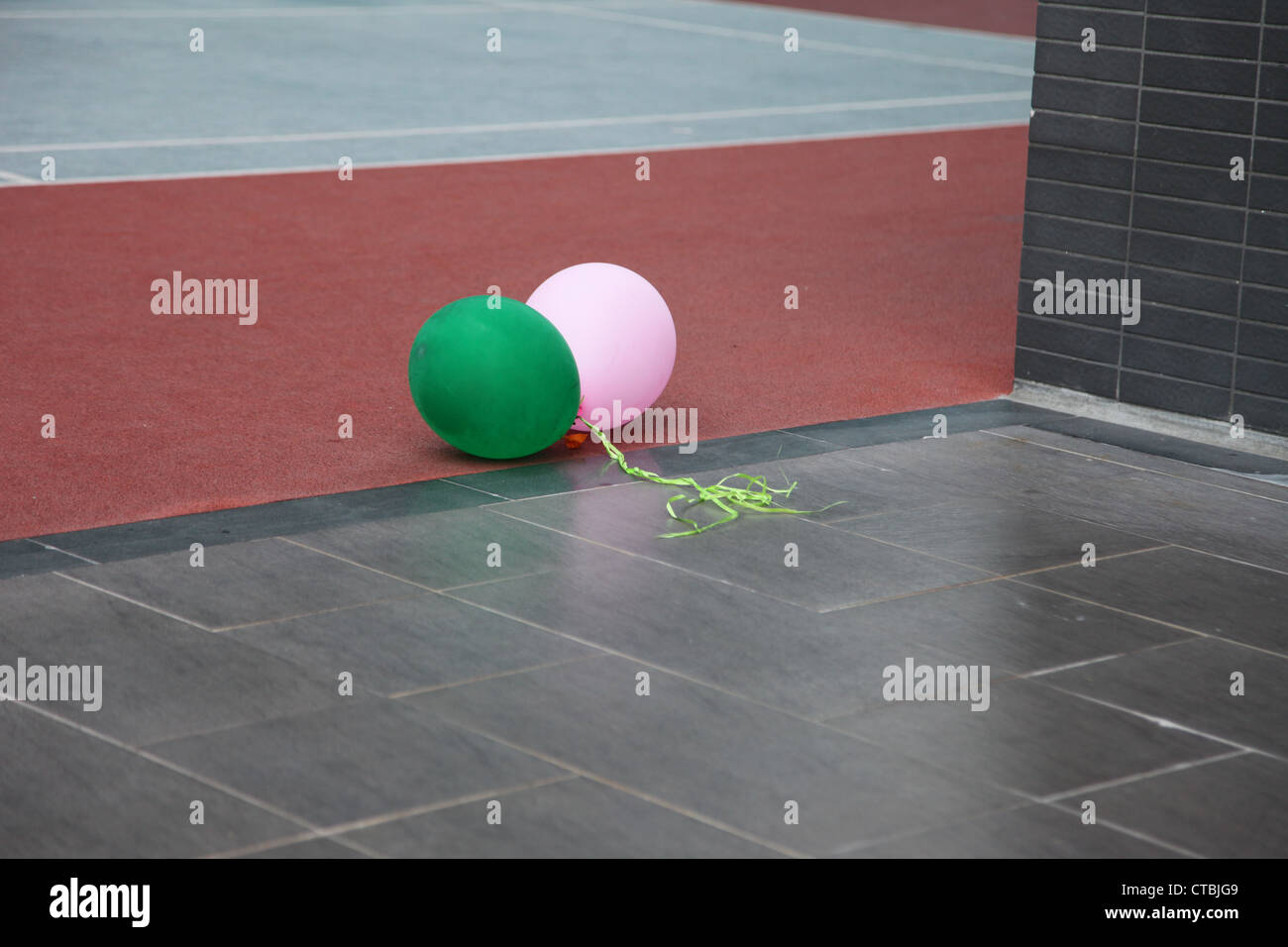 C'est une photo de 2 ballons qui sont sur le plancher pendant une fête d'anniversaire. Ils sont rose et vert et attachés ensemble voler loin Banque D'Images C'est une photo de 2 ballons qui sont sur le plancher pendant une fête d'anniversaire. Ils sont rose et vert et attachés ensemble voler loin Banque D'Images