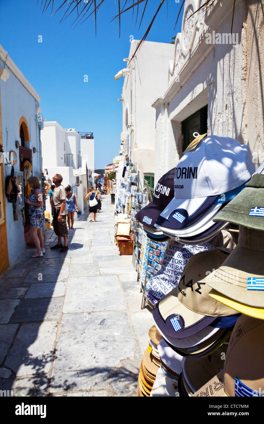 Rue étroite avec des magasins à Oia, Santorin île grecque Grèce caps pour la vente hors magasin Banque D'Images
