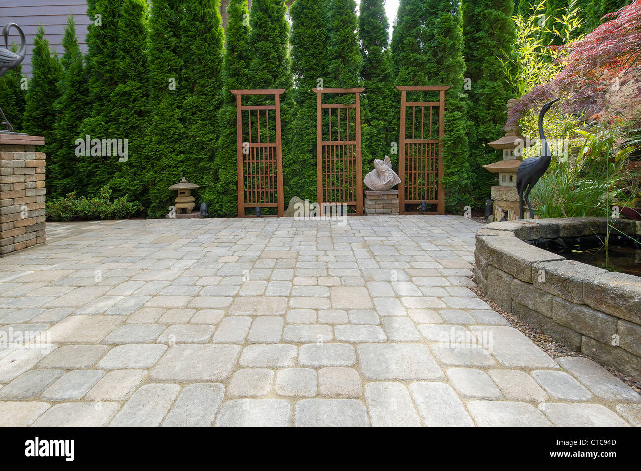 Arrière-cour jardin patio pavé avec étang Trellis pagode en pierre Décoration Sculptures bronze Crane Banque D'Images