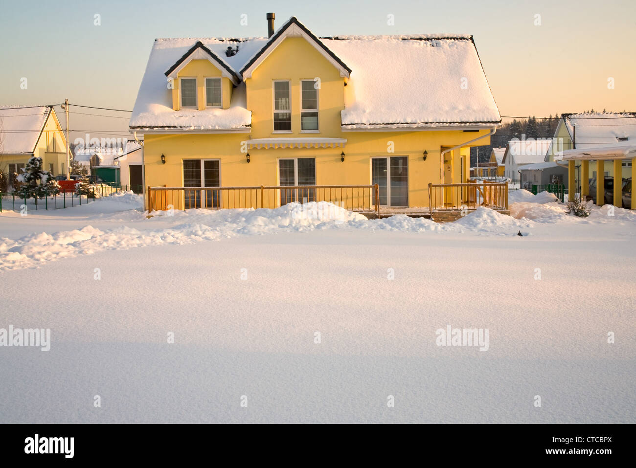 Maison de campagne à la lumière de soleil rose en hiver Banque D'Images