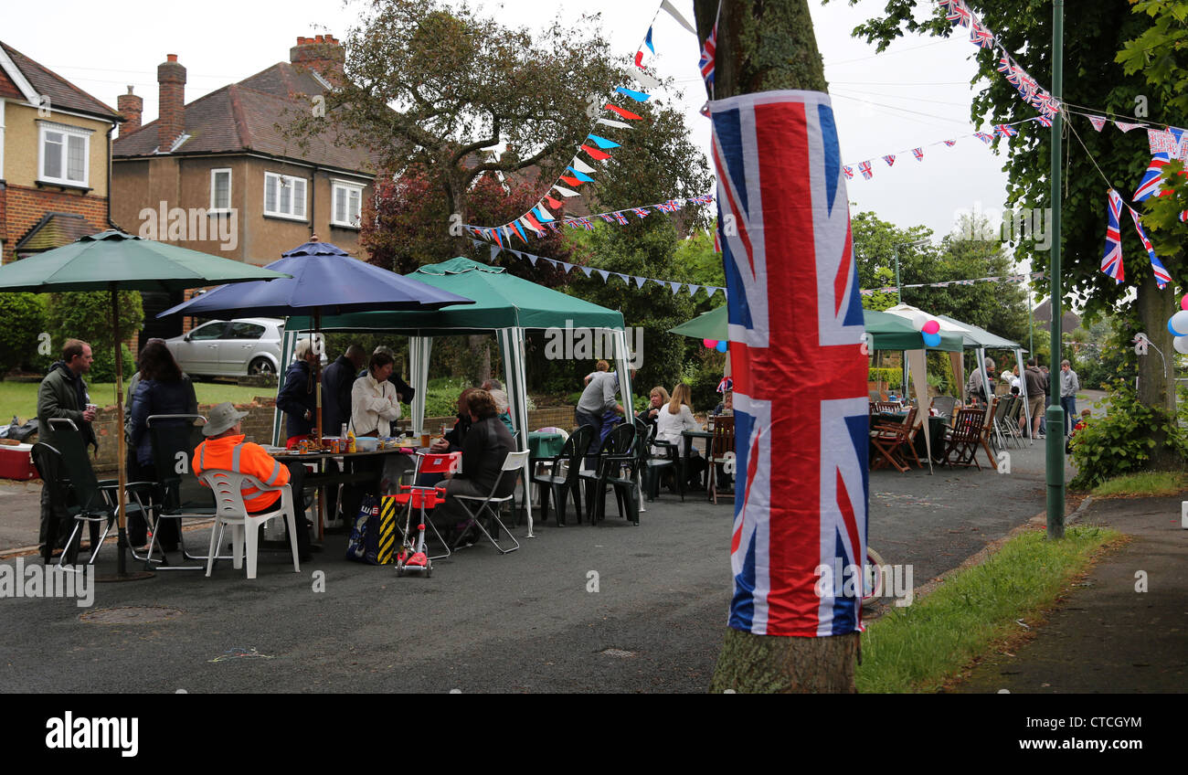 Les gens assis à l'ombre des parasols et chapiteaux à Street Party pour le Jubilé de diamant de la Reine Angleterre Surrey Banque D'Images
