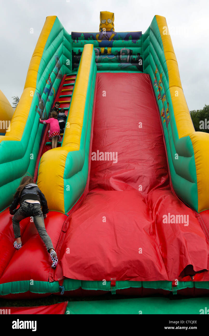 Les enfants de grimper Les Simpsons Diapositive gonflable Cheam Village juste Surrey England Banque D'Images