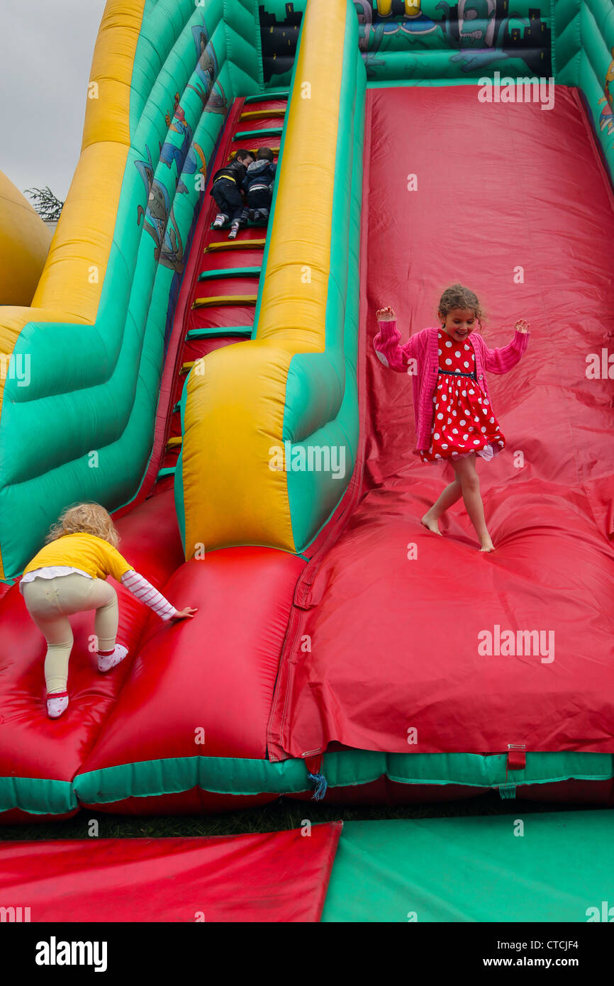Les enfants sur le toboggan gonflable Simpsons Cheam Village juste Surrey England Banque D'Images