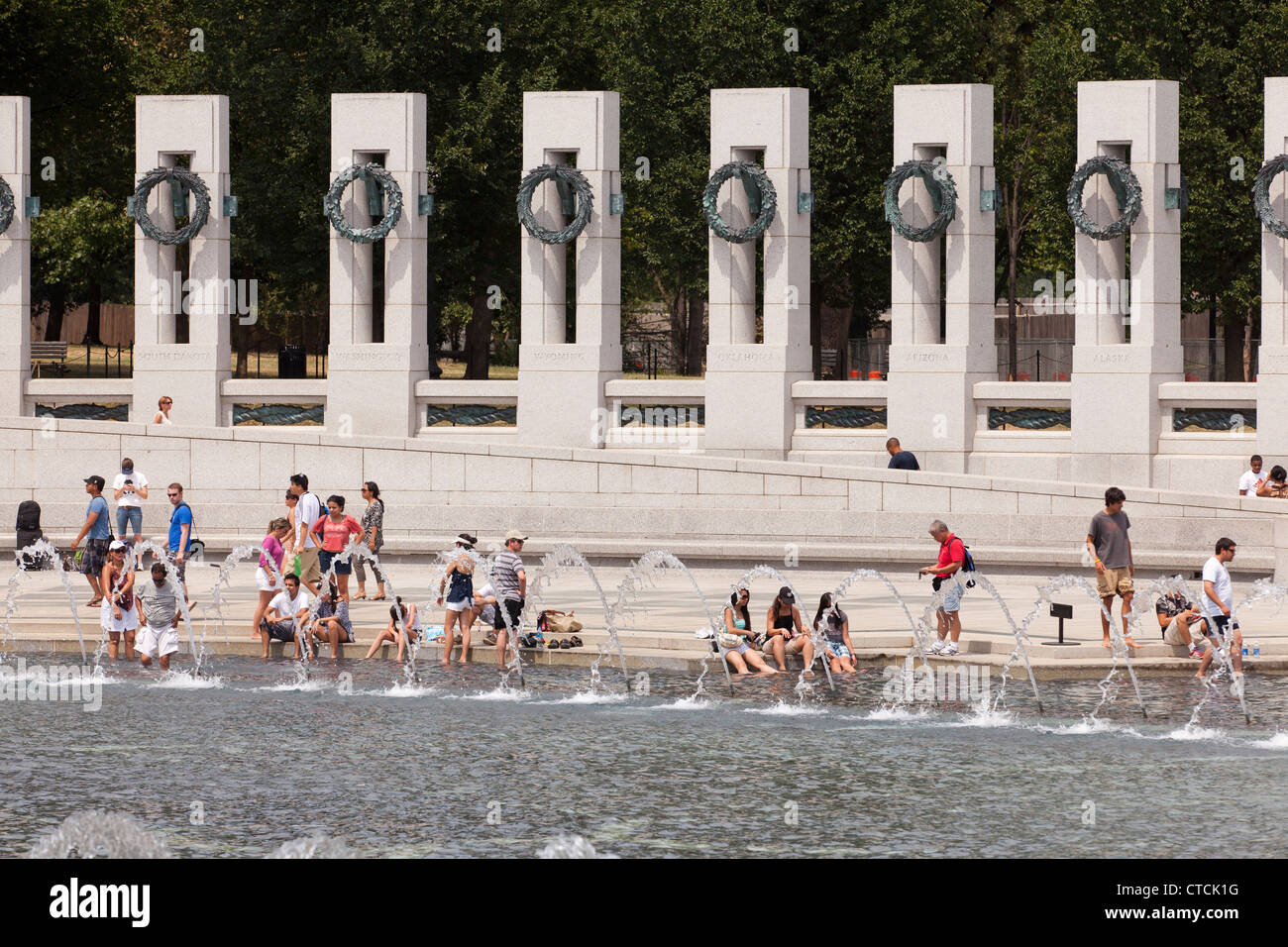 Visiteurs dunk les pieds dans la fontaine, trouver refuge contre la chaleur de l'été, tout en visitant le Mémorial de la SECONDE GUERRE MONDIALE Banque D'Images