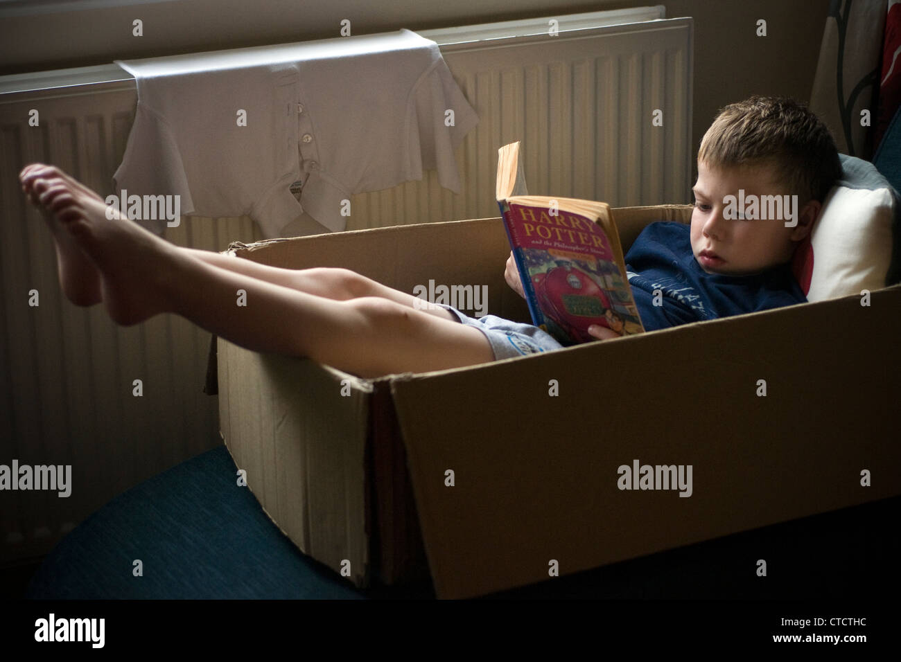 Boy reading livre de Harry Potter était assis dans la boîte en carton Photo  Stock - Alamy