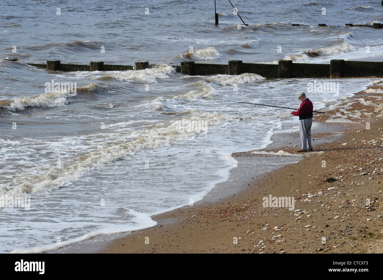 L'homme pêche en mer à partir de la plage, Hunstanton, Norfolk, England, UK Banque D'Images