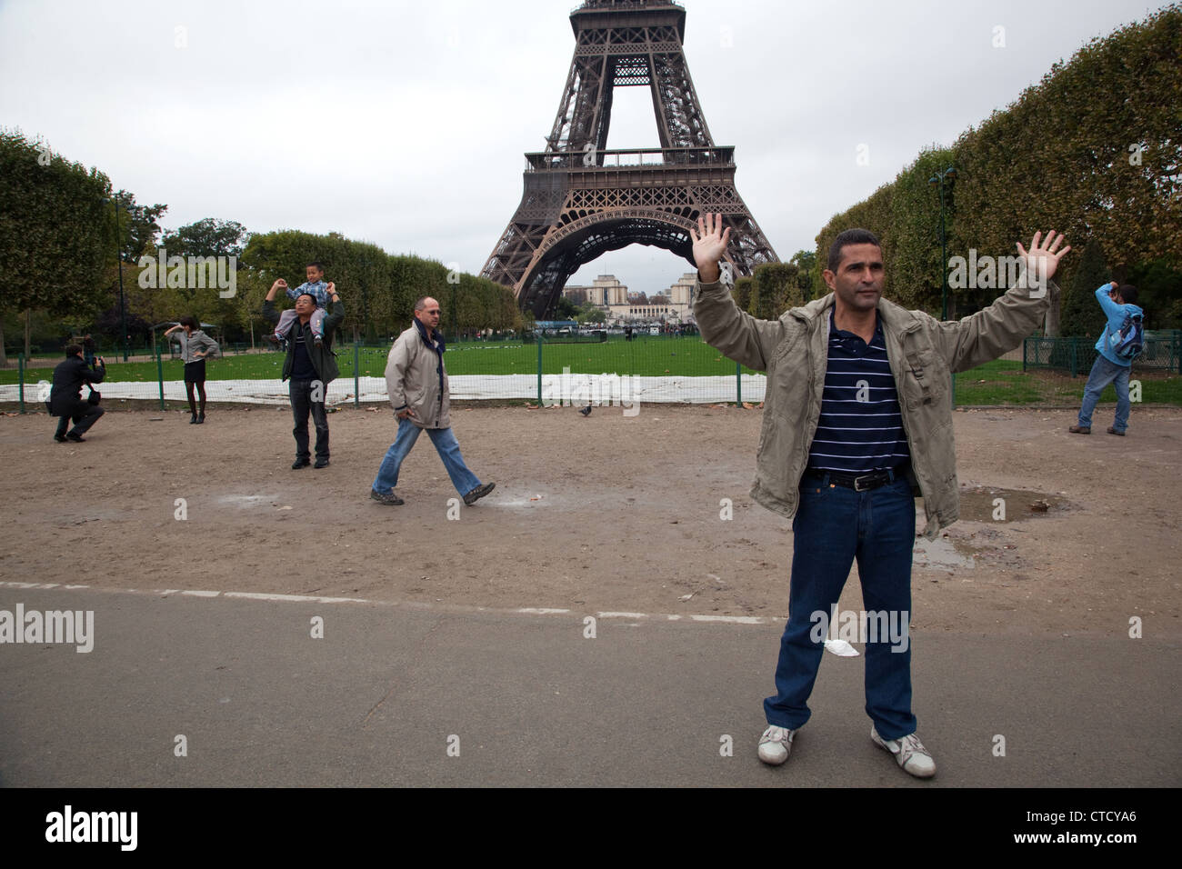 Des touristes posent pour des photos dans le parc près de la Tour Eiffel à Paris, France. Banque D'Images