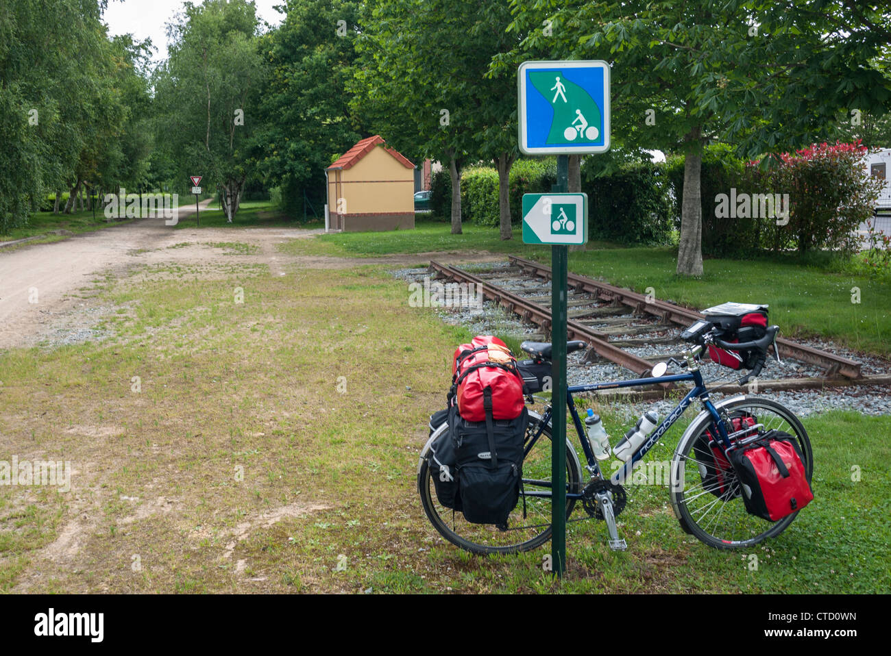 Randonnée vélo appuyé contre un poteau indicateur sur un velo route en Bretagne France Banque D'Images