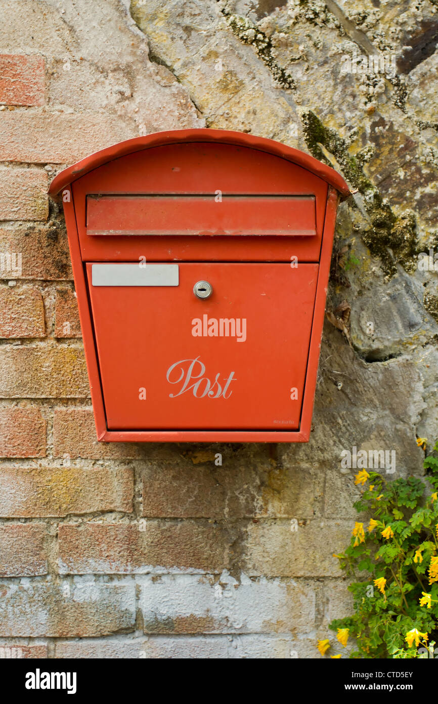 Métal rouge post box sur un vieux mur de brique Banque D'Images