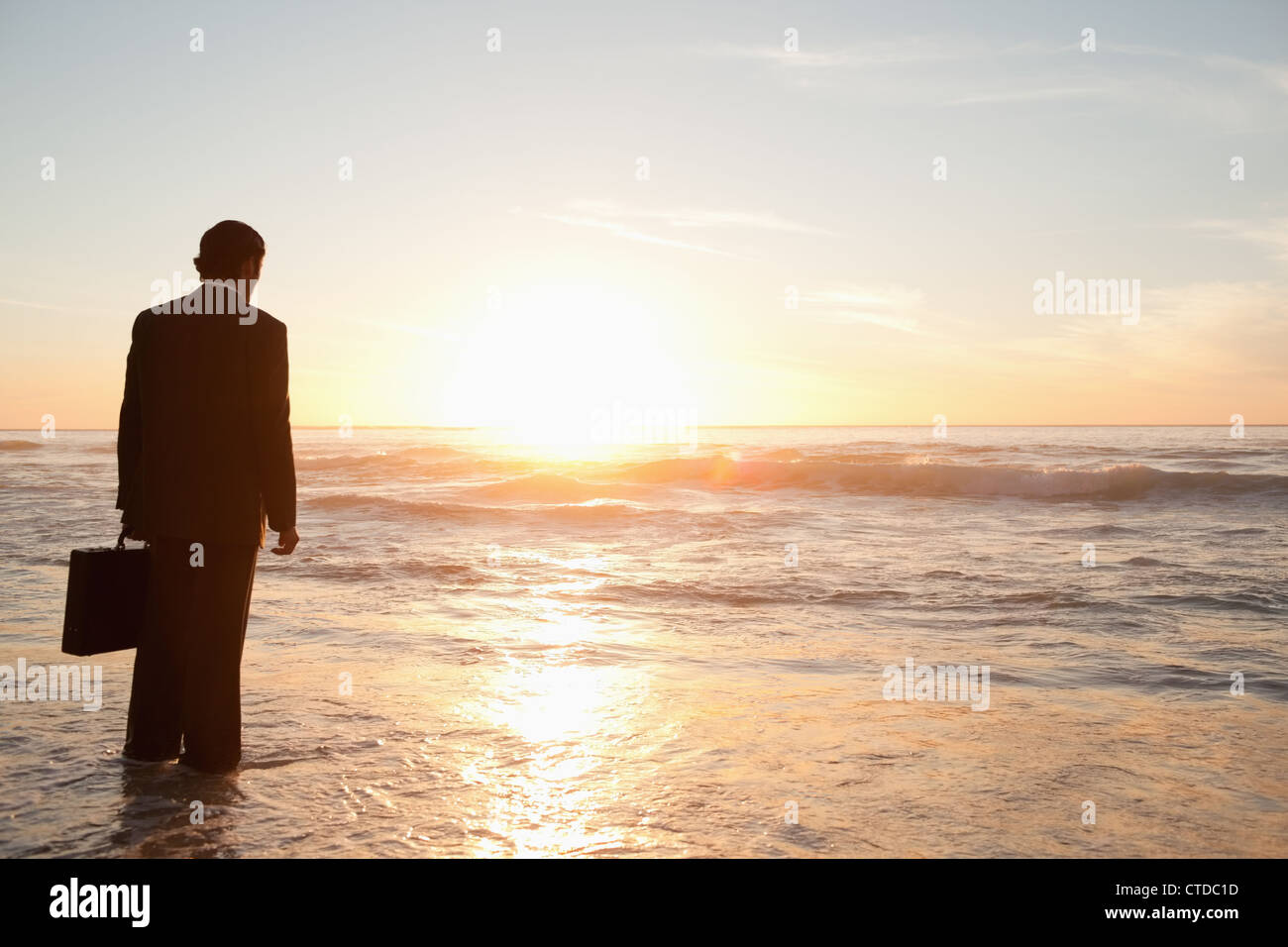 Businessman standing dans le sable humide Banque D'Images