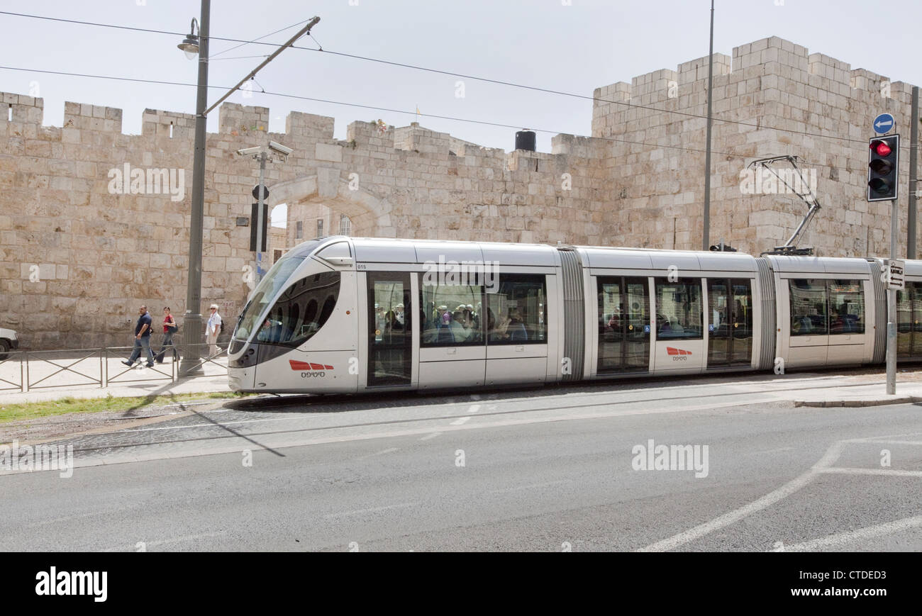 Train léger sur rail moderne à l'extérieur de la nouvelle porte et des murs du vieux Jérusalem, Israël Banque D'Images