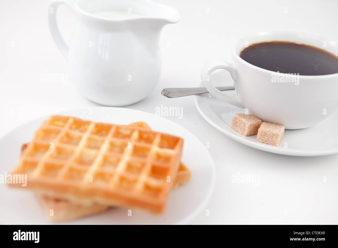 Lait Sucre gaufres et une tasse de café sur la plaque blanche avec cuillère Banque D'Images